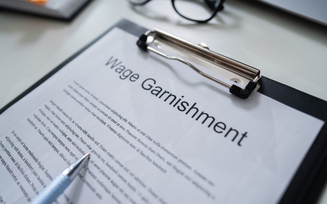 Wage garnishment document on clipboard, emphasizing tax-related legal issues, with a pen pointing to the text, relevant to IRS wage garnishment discussions.