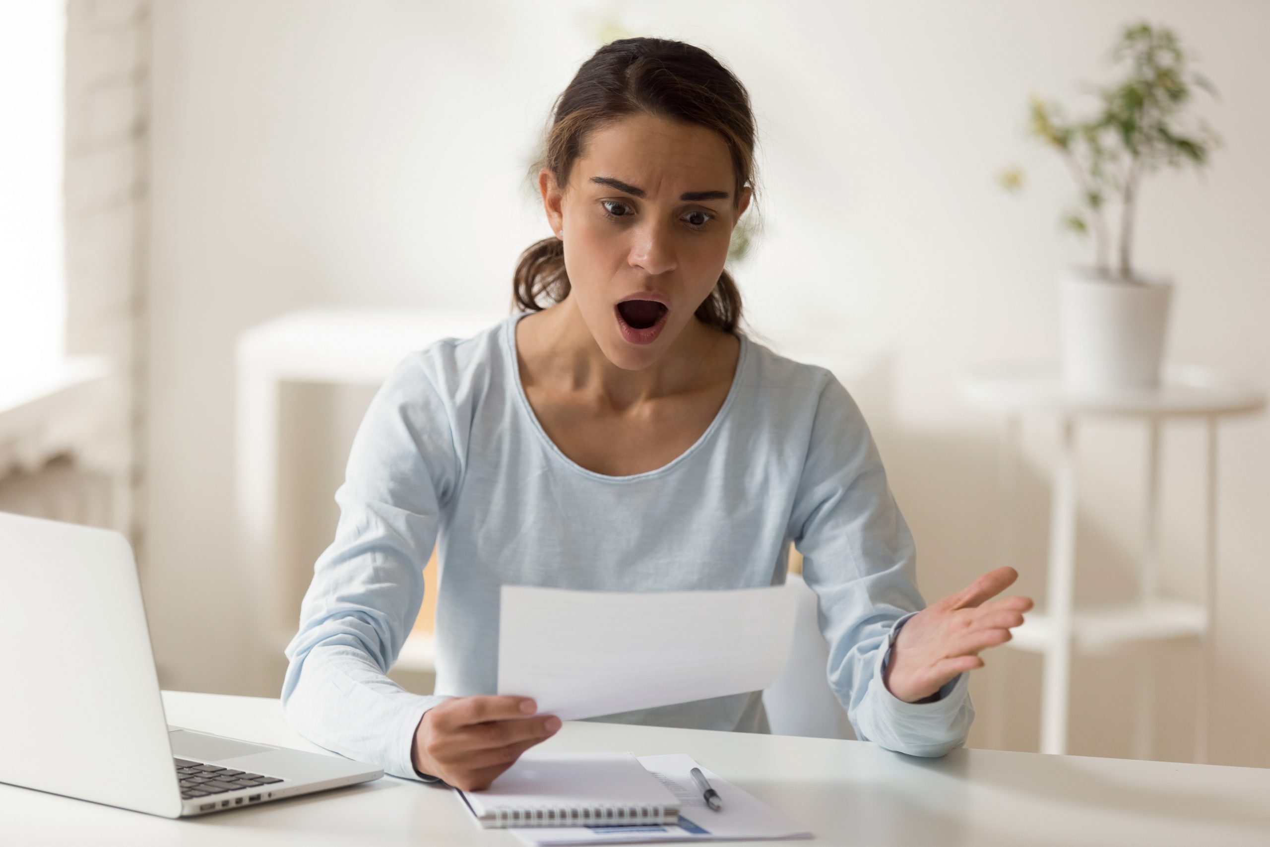 Shocked,And,Confused,Woman,Looking,At,Paper,At,Desktop.,Emotional